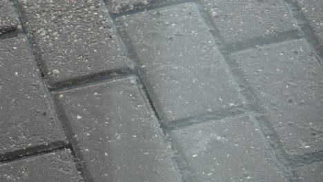 Raindrops-fall-on-a-paved-road