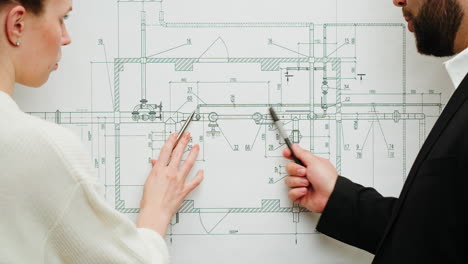 two professionals discussing an engineering or architectural blueprint