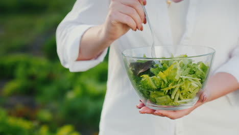 una mujer come una ensalada cerca de la cama donde crece