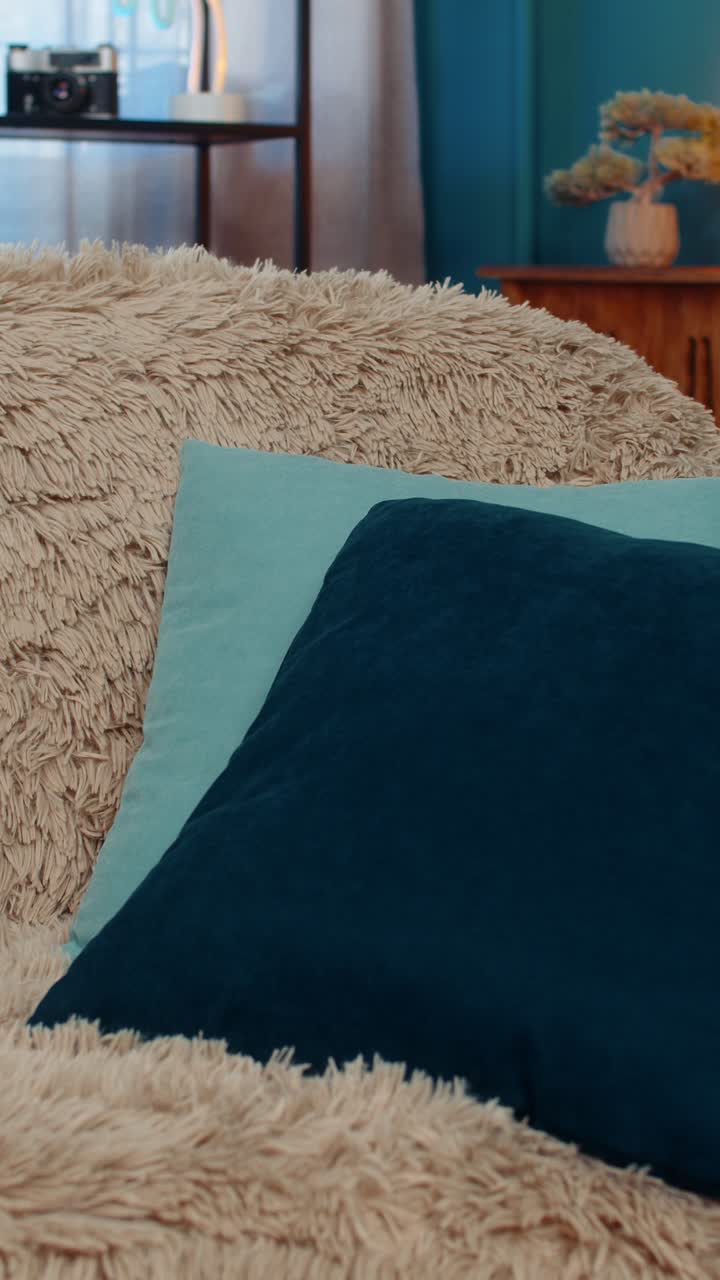 Donna che si addormenta stanca dopo una giornata estenuante, avvolta in una coperta, con la testa appoggiata sul cuscino sul divano