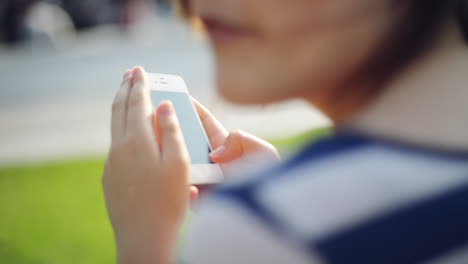 Mujer,-Mensajes-De-Texto,-Teléfono-Móvil,-En,-Parque-De-La-Ciudad