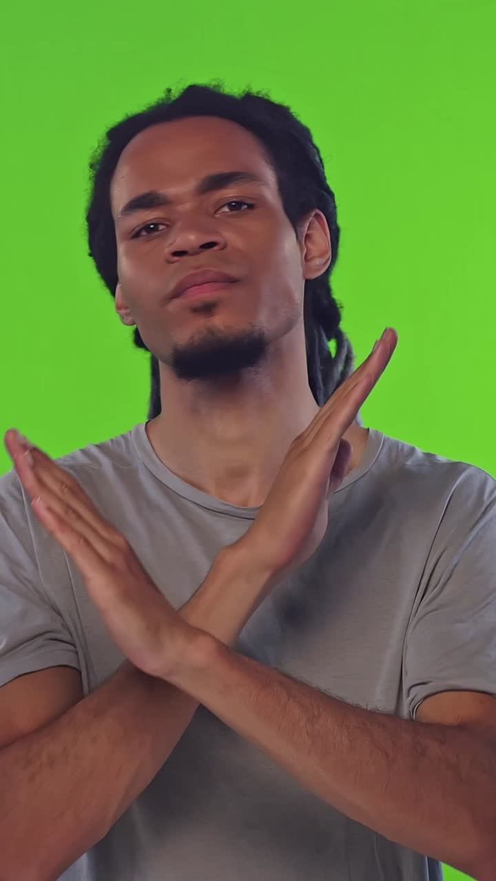 Young Man with Dreadlocks Making Stop Gesture on Green Screen