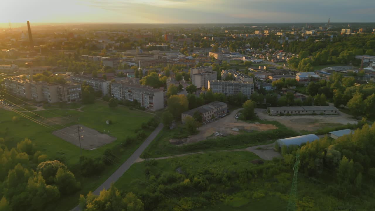 해가 지는 하늘 아래 라트비아의 다우가브필스 시의 영화적인 항공 전망