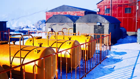 bright yellow tanks stand out against snowy landscape in industrial area