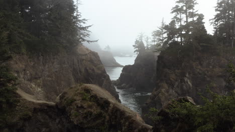 Drone-shot-flying-in-middle-of-cliffs-in-misty-Samuel-H