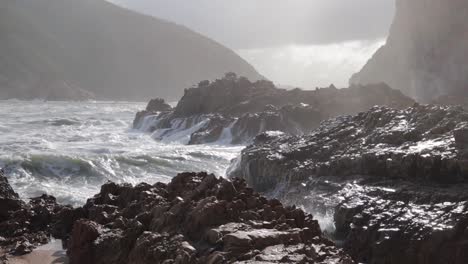 Las-Olas-Oceánicas-Espectrales-Plateadas-Chocan-Violentamente-Contra-Las-Soleadas-Rocas-De-La-Costa