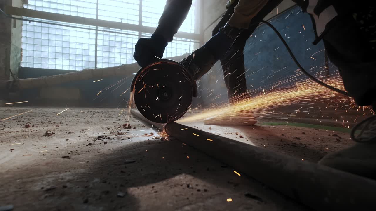 건설 노동자가 원형 도자기로 강철을 자르고, 건설 노동자의 발, 원형 도에서 날아오는 불꽃, 느린 동작