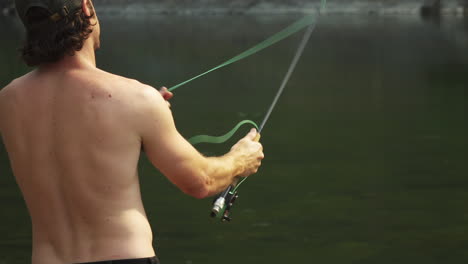 fly-fishing, a man gets his line tangled around the rod whilst fly-casting during a camping trip to glacier national park