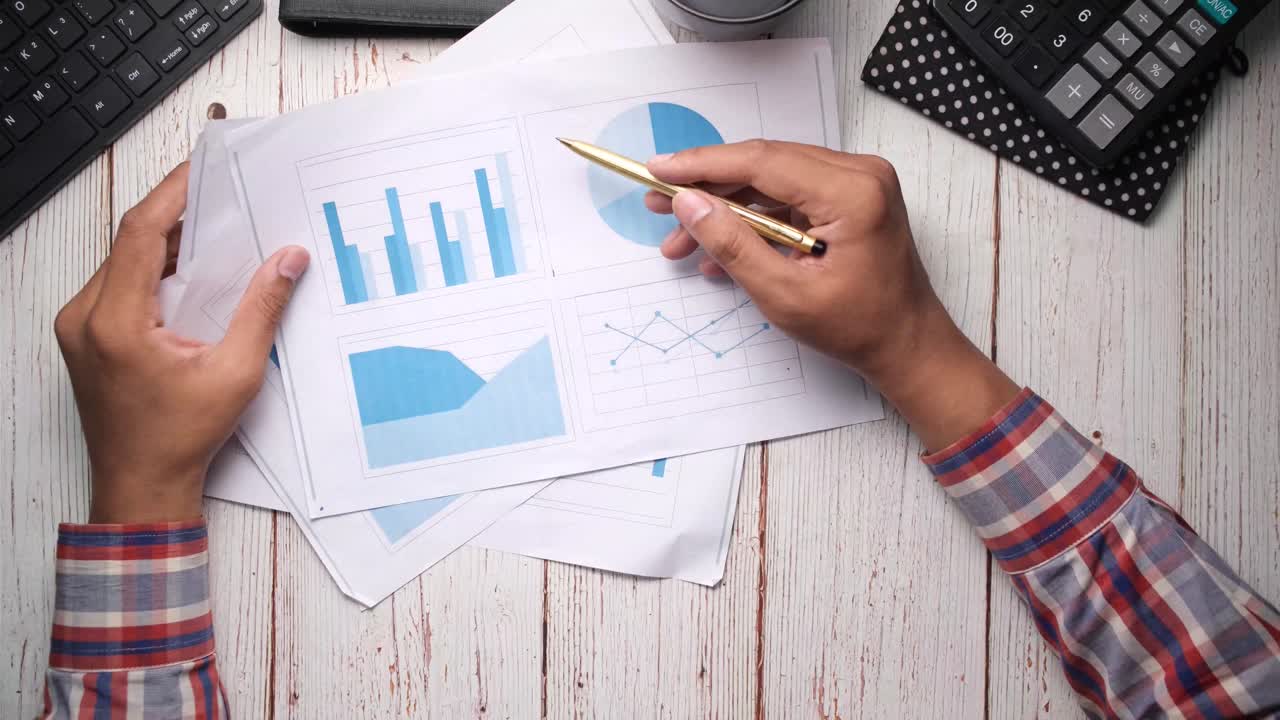 persona que revisa los documentos y gráficos financieros
