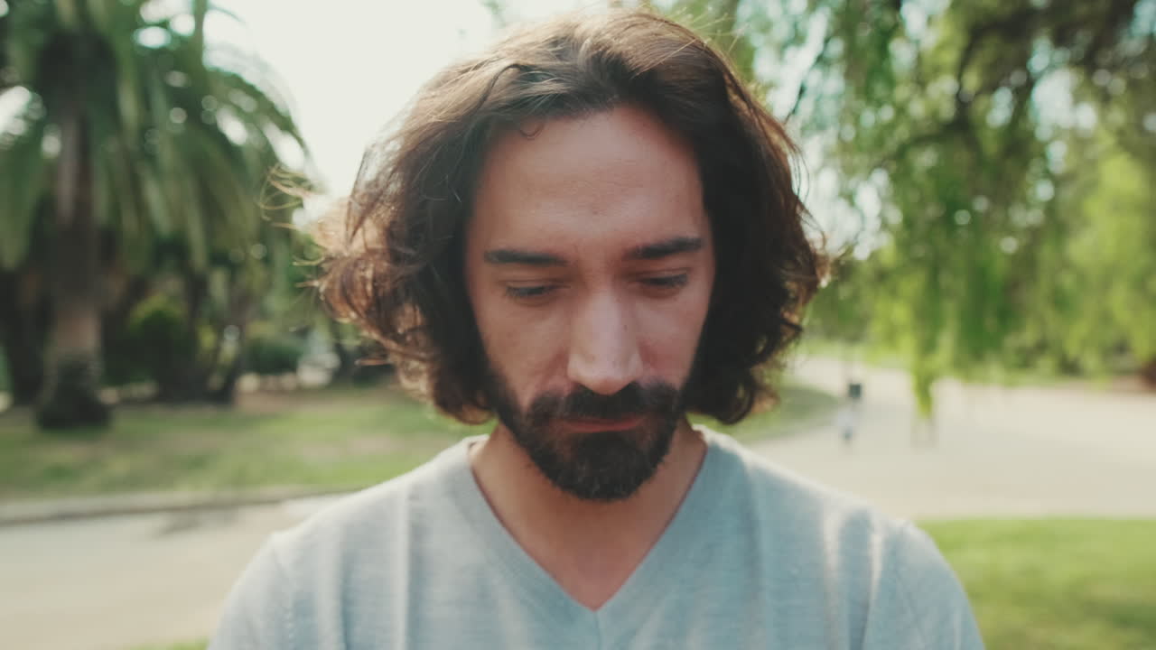 Portrait of a man with beard and long hair in a park