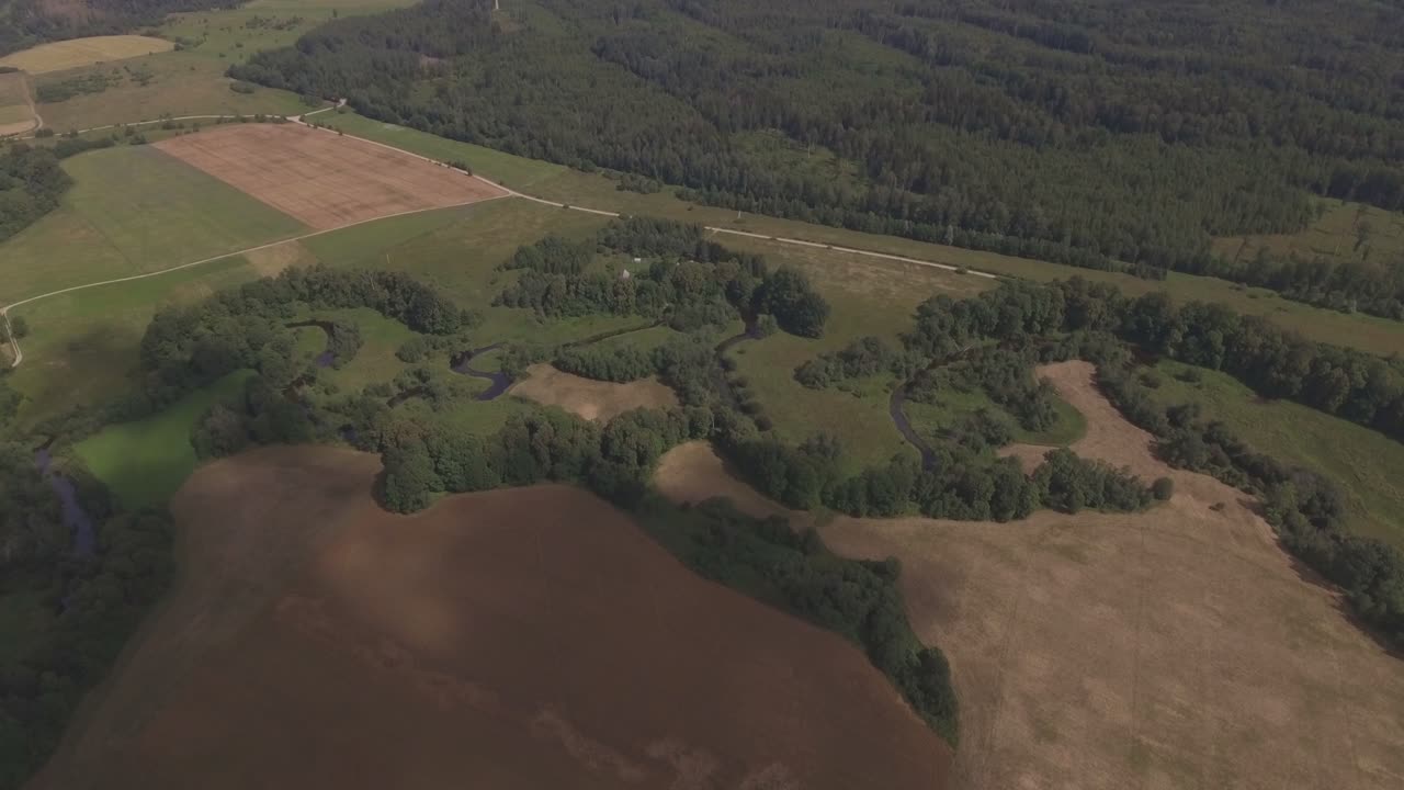 The River Winds Between Green Fields And Trees. Aerial Forward
