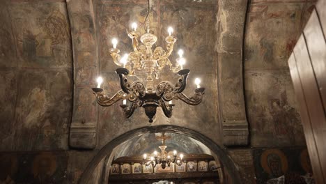 large golden chandelier hanging in an old beautiful church