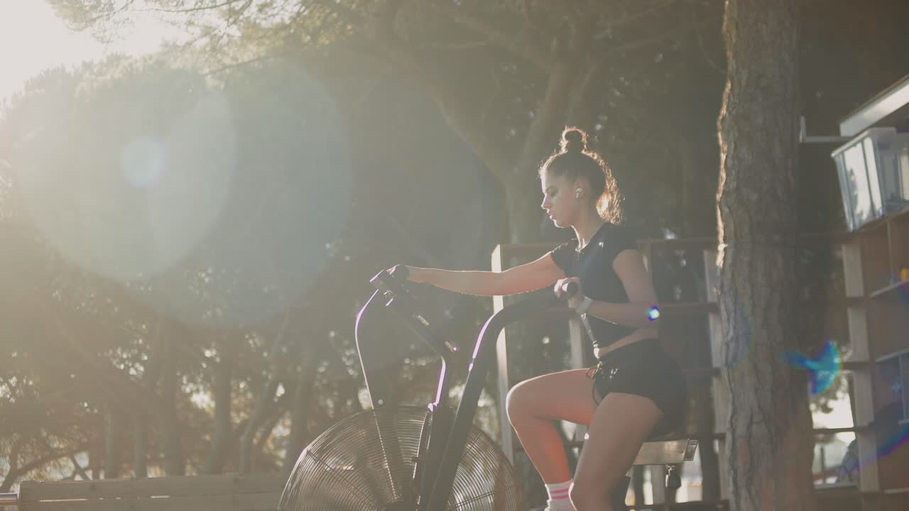 Woman exercising on an air bike outdoors