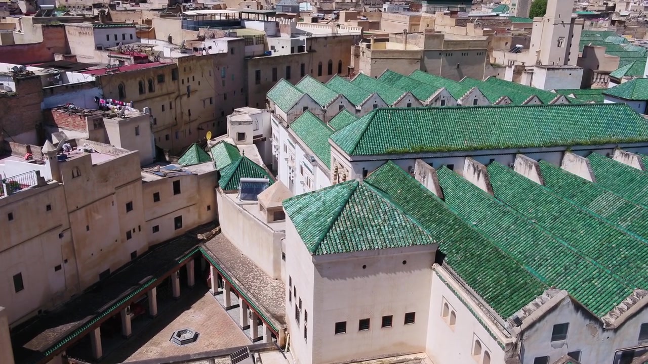 Vista aerea con drone di tetti in tegole verdi e architettura tradizionale marocchina nella storica Medina di Fez, ideale per progetti culturali e di viaggio.