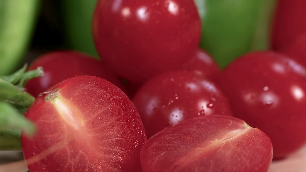 신선한 체리 토마토의 활기찬 클로즈업, 녹색 배경에 대한 풍부한 빨간색과 맛있는 질감을 강조합니다.