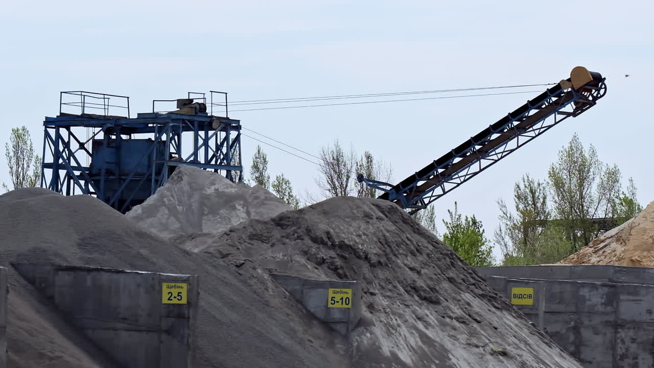 Piles of gravel outdoors. Industrial factory for production construction materials. Metal construction for crashing stones and rocks.