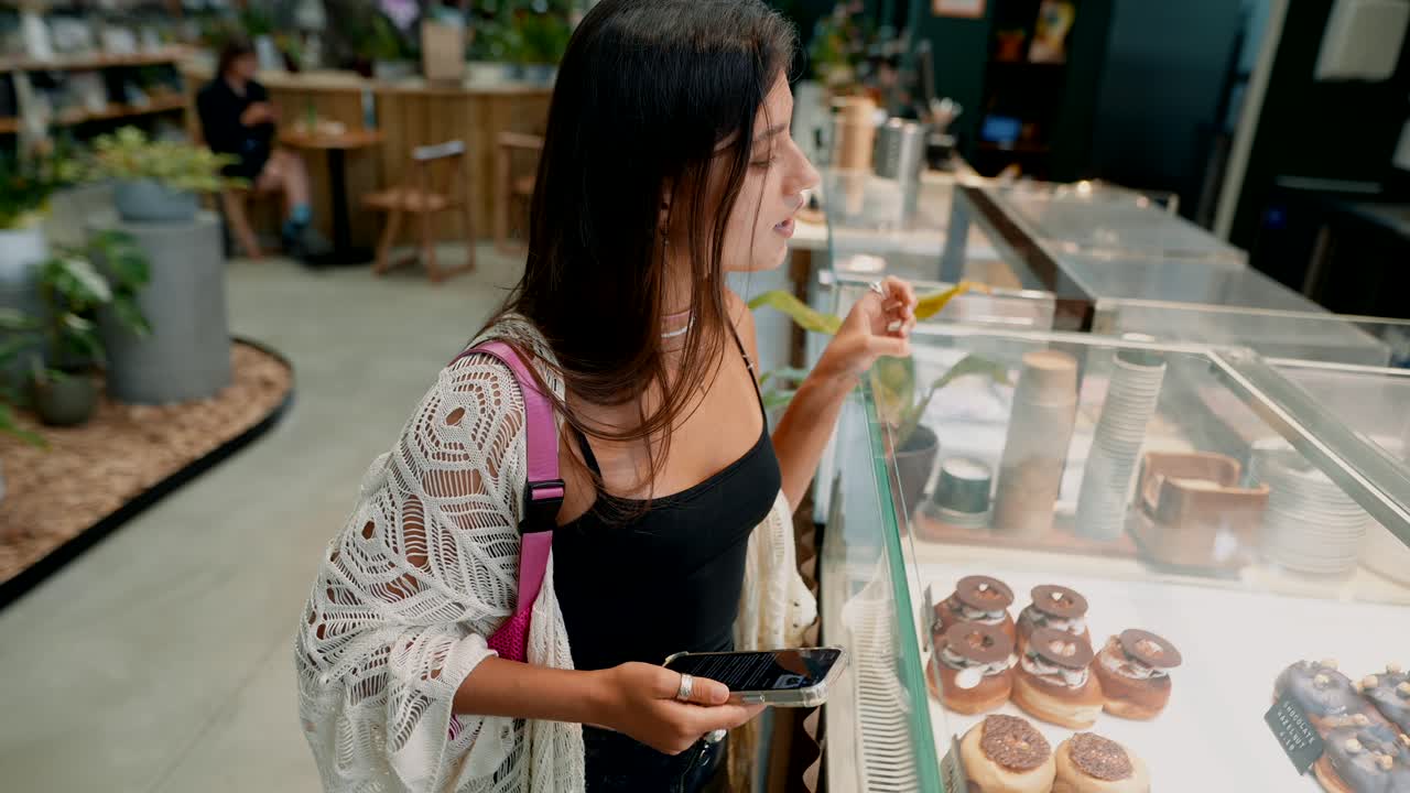 Woman looking at desserts in a cafe