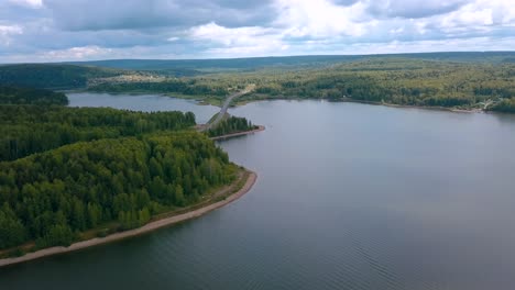 aerial view of a lake, forest and road