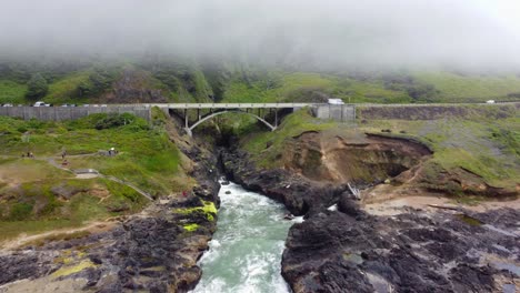 4K-30FPS-Aerial-Footage-of-Thor's-Well,-Spouting-Horn,-Highway-101-along-the-Oregon-Pacific-Northwest-Coast---Aerial-View-Turquoise-Blue-Water,-Mossy-Rock---Tracking-In-Flying-Shot-Smooth-DJI-Drone