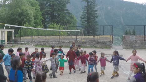 manali, india, circa 2019 - western woman gets young children into a circle in an activity, at a village school in the himalayas