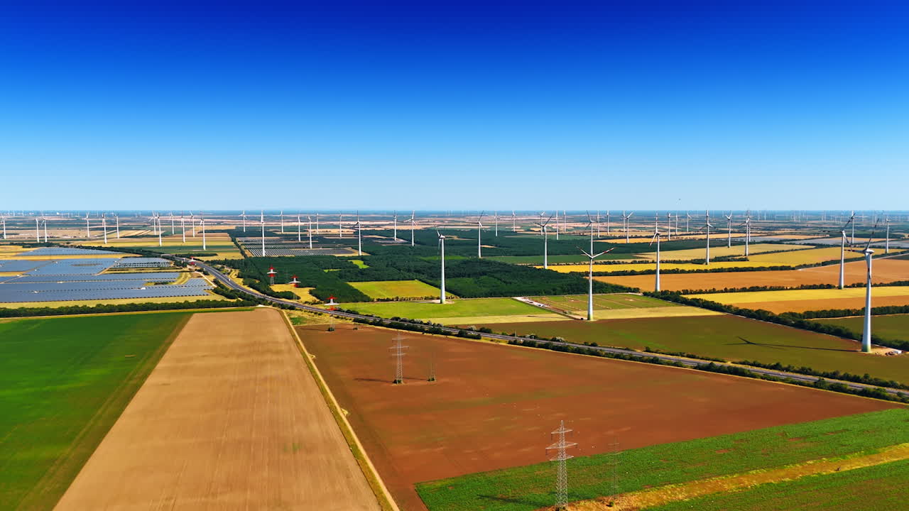 Energy production concept. Wind farms, electricity power lines and solar panel sites in the field. Aerial view