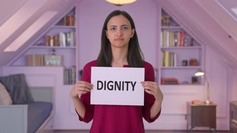 sad indian woman holding dignity banner