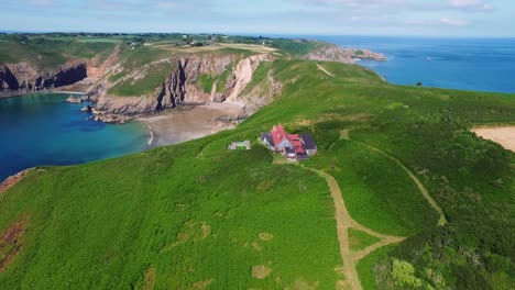 Drone-Ascendente-Que-Revela-Una-Gran-Casa-De-Verano-Aislada-En-Un-Maravilloso-Entorno-Costero-Natural-En-La-Isla-De-Sark