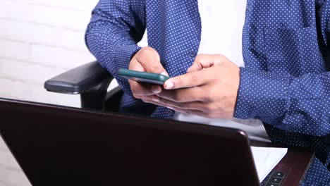 persona que utiliza un teléfono inteligente y una computadora portátil