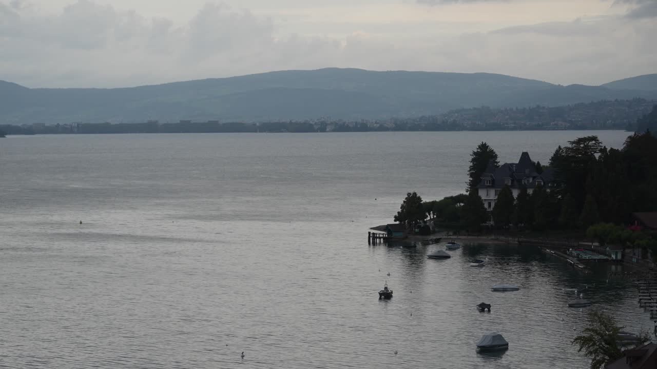 lapso de tiempo de los barcos flotando en el lago annecy en los alpes franceses con nubes onduladas, tiro ancho