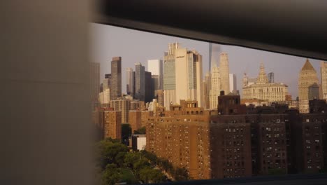 slow motion shot showing beautiful golden skyline of new york at golden hour - view from car window during crossing bridge -