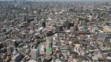 aerial scenic urban drone footage of a neighborhood, streets and buildings in the capital city of tokyo, japan on a sunny day