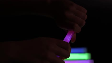 hands activating and arranging colorful glow sticks