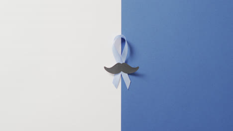 video de bigote de papel y cinta azul pálido de cáncer de próstata sobre fondo blanco y azul