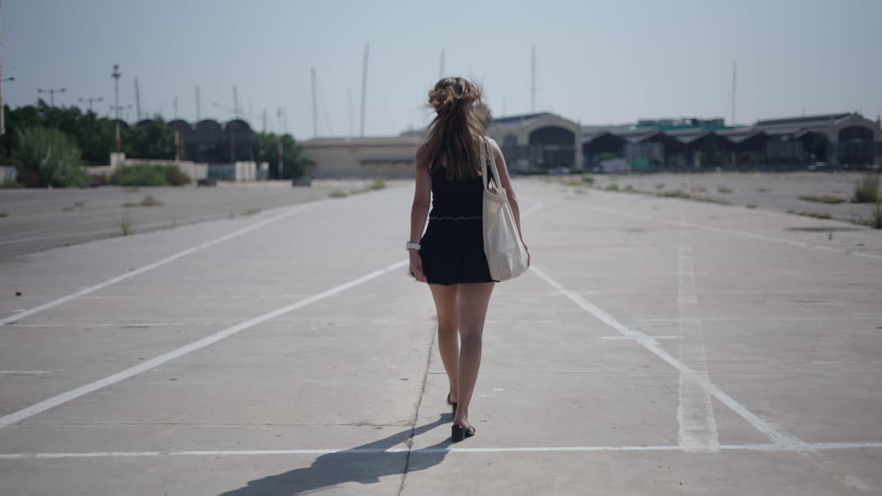 Woman walking in an empty parking lot
