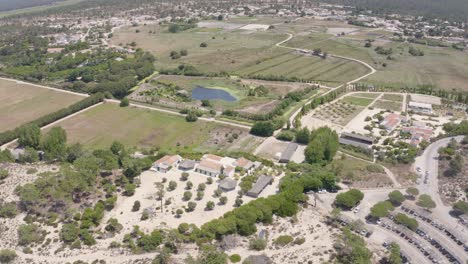 aerial-view-of-Praia-do-Carvalhal-surrounded-by-dunes-and-bathed-by-a-calm-sea,-giving-way-to-pine-trees,-the-immense-beach