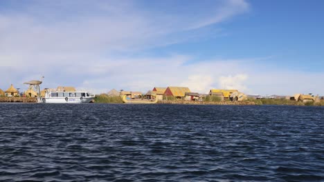 cruising alon the uros island on lake titicaca, puno, peru, south america