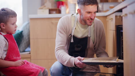 boy accompanies dad while baking christmas cookies