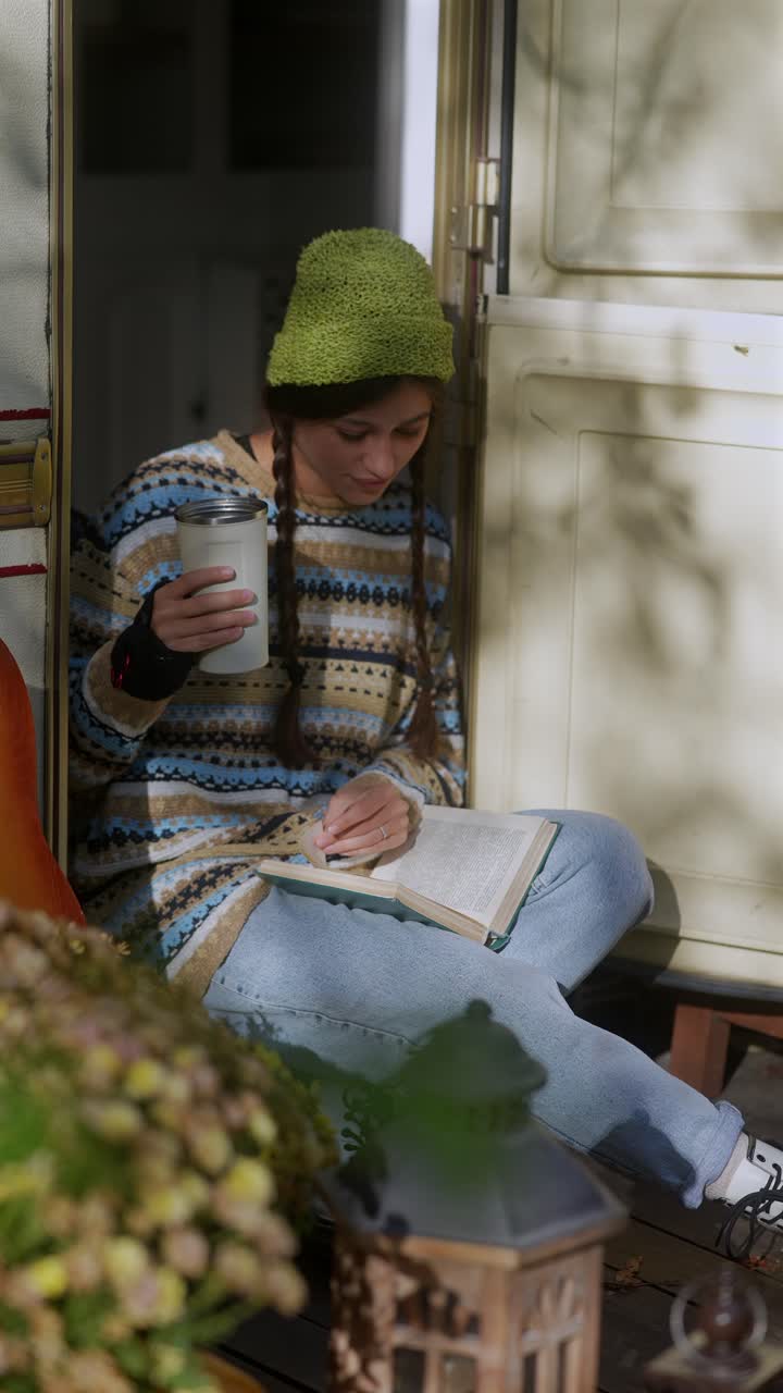 Donna che legge un libro all'aperto in un'accogliente ambientazione da campeggio