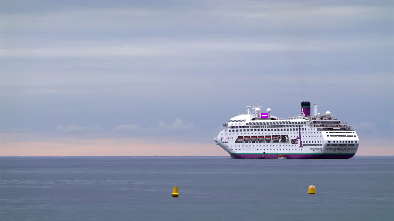 La Condamine, Monaco - July 4, 2025: A white cruise ship floating on calm water with navigation buoys in front