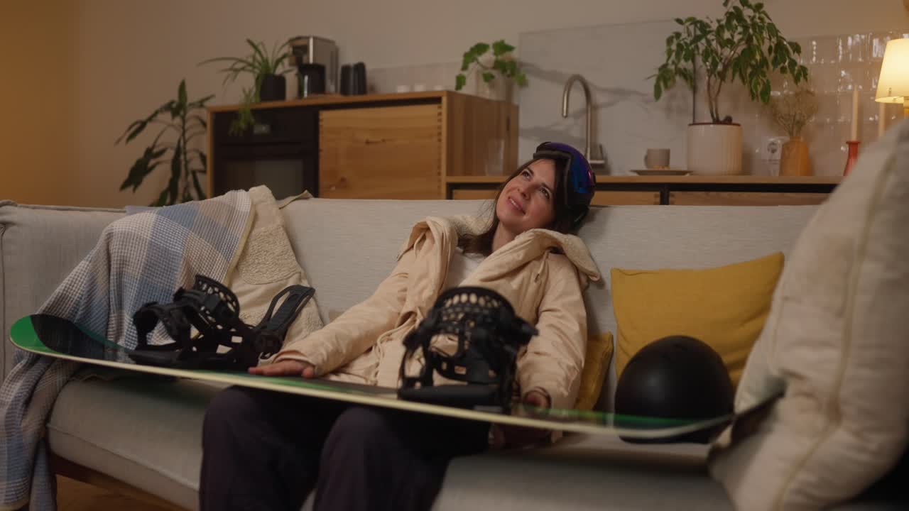 Woman relaxing on a couch with her snowboard