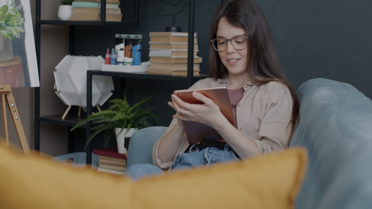 mujer relajándose en un sofá usando una tableta