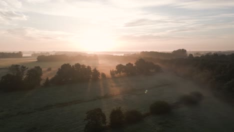 sunrise over a misty field and forest
