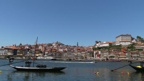 timelapse of river duoro on stunning clear summer european day with boats sailing down river and ribeira in background with colorful houses and buildings, porto, portugal.