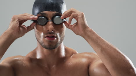 focused swimmer adjusting goggles