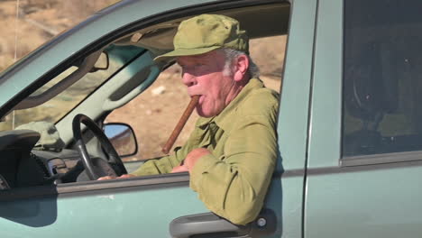 old man in suv with cigar in his mouth drives by, off-roading