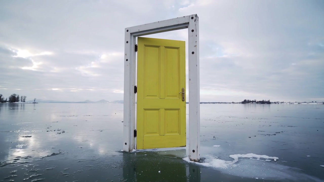Una porta gialla in una cornice bianca si chiude delicatamente su un lago ghiacciato, con una brezza leggera che diffonde l'acqua di disgelo.
