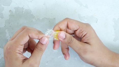 unwrapping a yellow candy