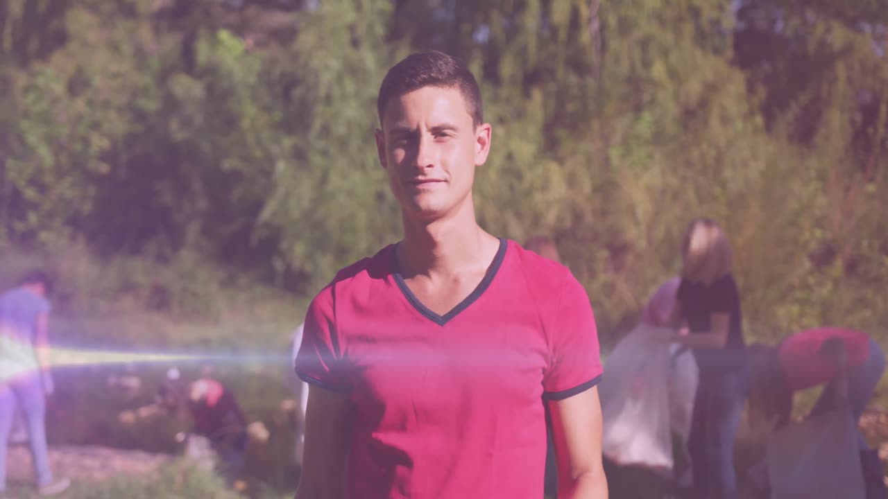 video de luces sobre un hombre caucásico feliz recogiendo basura con voluntarios en el campo