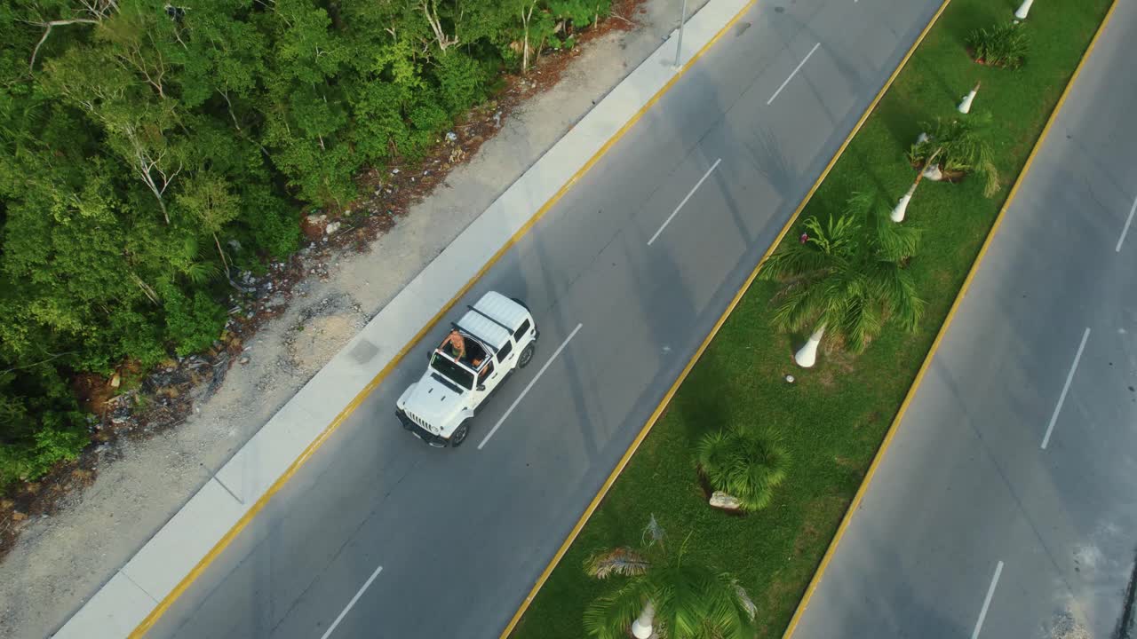 Veduta aerea con drone di un'auto bianca che guida su una strada a Tulum, Messico.