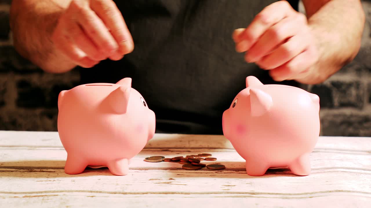 Suddivisione del denaro in parti uguali tra due salvadanai, concetto di distribuzione finanziaria